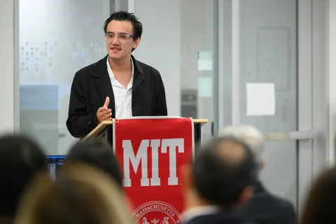 Daniel Prato presenting at a podium that reads "MIT"